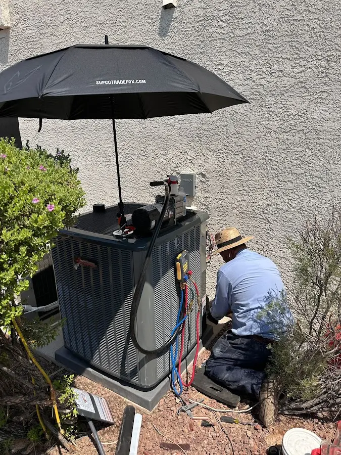 HVAC technician performing outdoor AC maintenance in Findlay